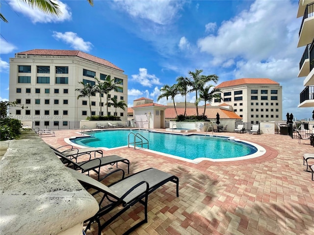 view of pool with a patio area and a shed