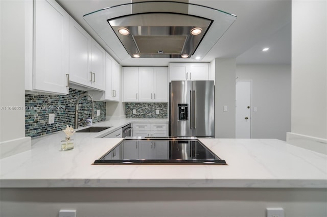 kitchen with decorative backsplash, high quality fridge, light stone countertops, white cabinetry, and a sink