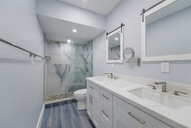 bathroom with toilet, a marble finish shower, a sink, and wood finish floors