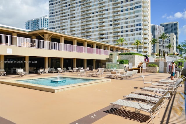 view of swimming pool featuring a view of city and a patio