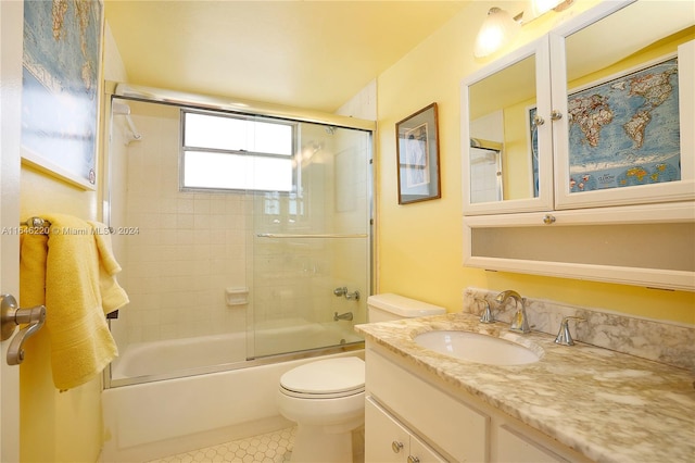 full bathroom with tile patterned flooring, bath / shower combo with glass door, vanity, and toilet