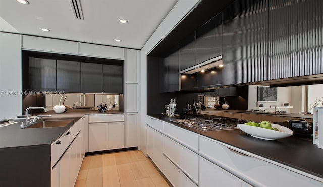 kitchen featuring light hardwood / wood-style floors, sink, white cabinetry, and stainless steel gas stovetop