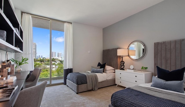 carpeted bedroom featuring access to exterior and a wall of windows