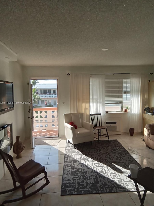 tiled living room featuring a wall mounted AC and a textured ceiling