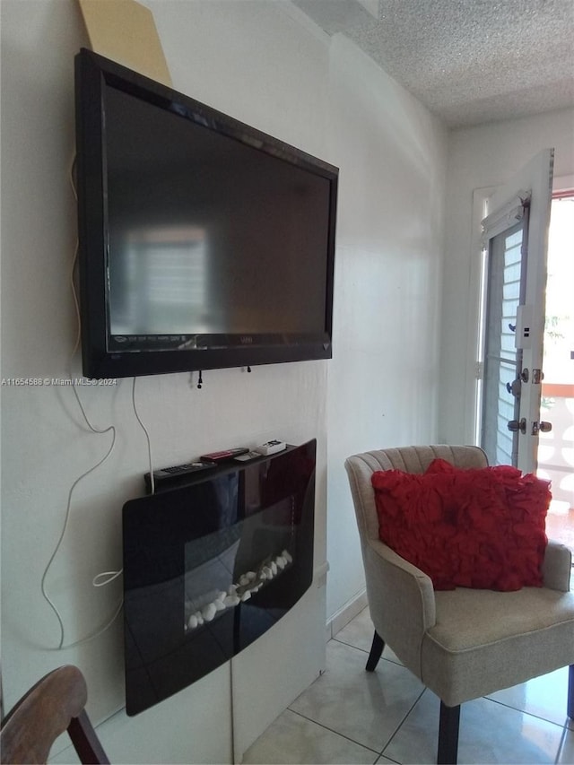 living room with a textured ceiling and light tile patterned flooring