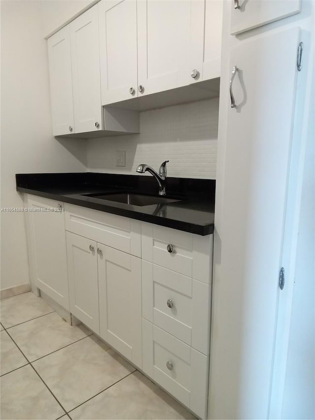 kitchen with white cabinets, light tile patterned floors, and sink