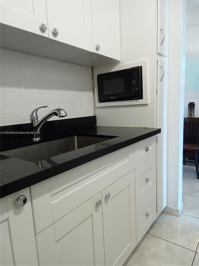 kitchen with white cabinetry, sink, and light tile patterned floors