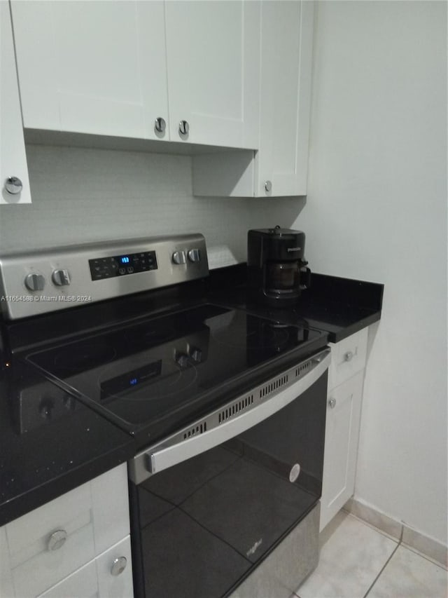 kitchen featuring backsplash, white cabinetry, stainless steel range with electric cooktop, and light tile patterned flooring