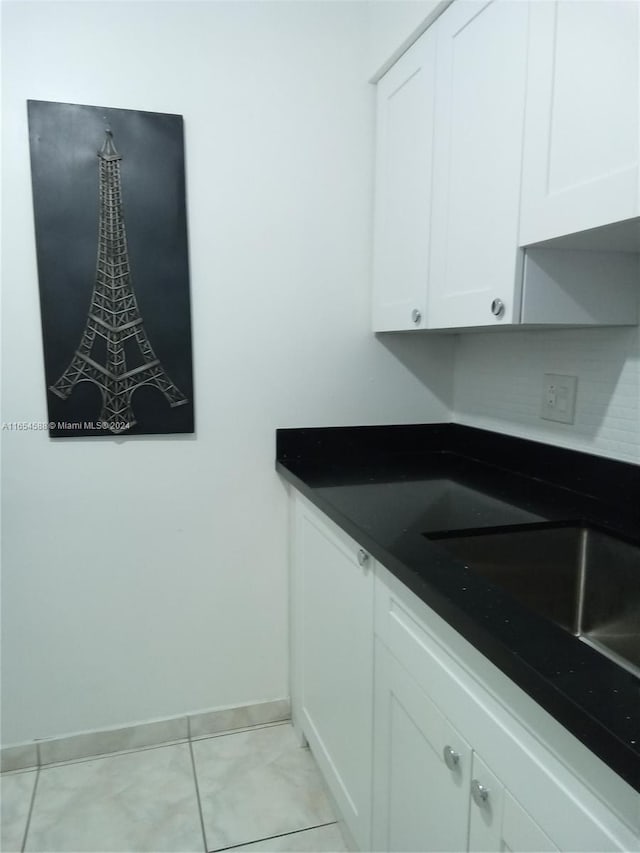 kitchen with white cabinetry, sink, and light tile patterned floors