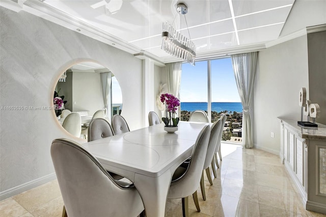 dining area featuring crown molding, a water view, baseboards, and arched walkways