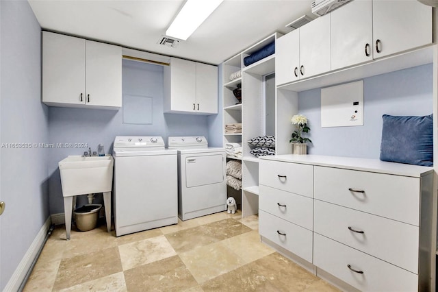 laundry room with separate washer and dryer and cabinets