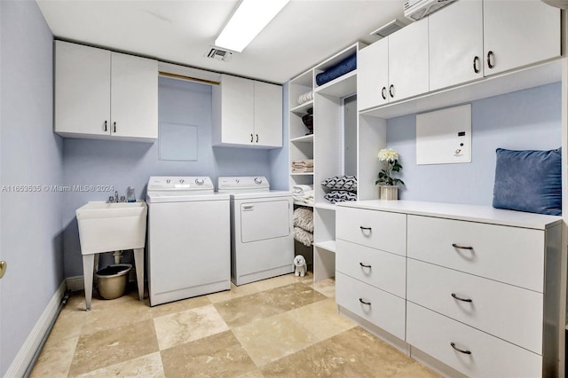 laundry area featuring visible vents, baseboards, stone finish flooring, washer and clothes dryer, and cabinet space