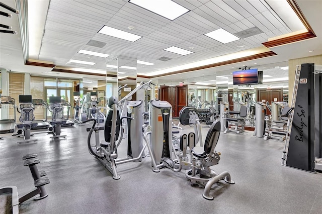 workout area with a tray ceiling and visible vents
