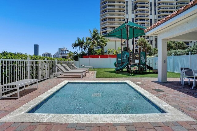 view of pool featuring a patio area, fence, and playground community