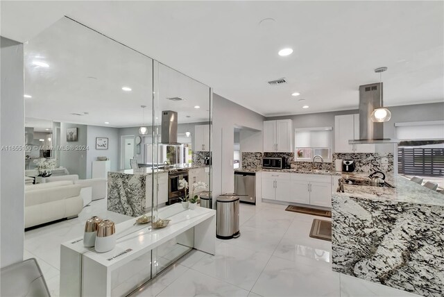 kitchen featuring white cabinets, pendant lighting, stainless steel appliances, island exhaust hood, and wall chimney range hood