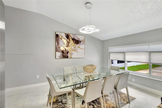 dining room featuring lofted ceiling and a chandelier