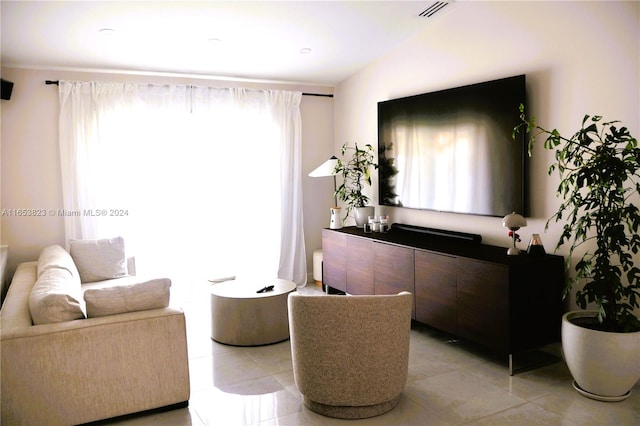 living room featuring light tile patterned flooring and vaulted ceiling