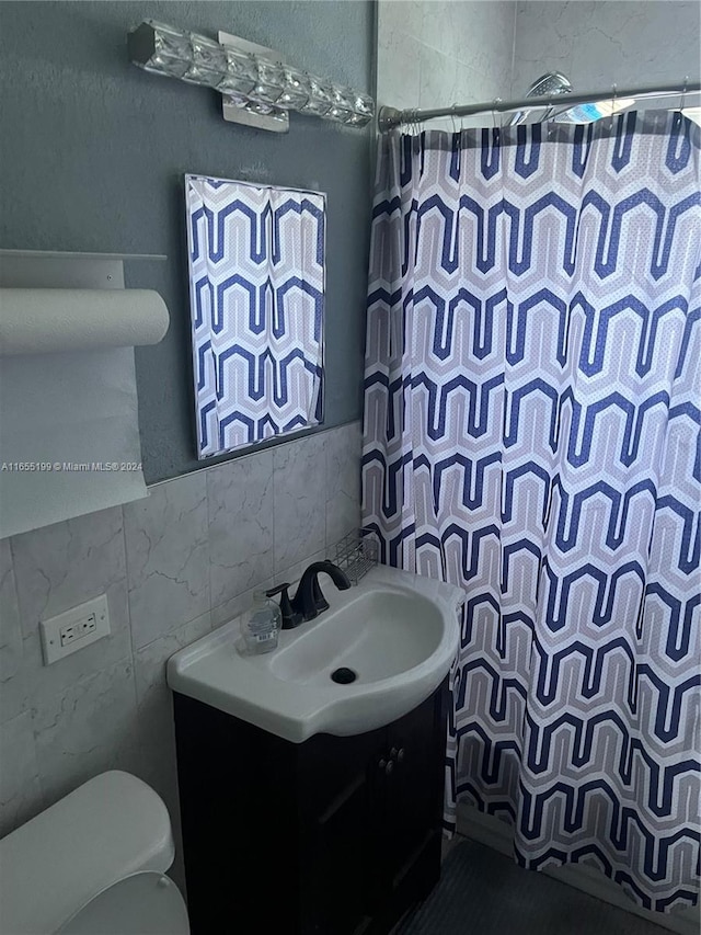 bathroom featuring vanity, toilet, a shower with curtain, and tile walls