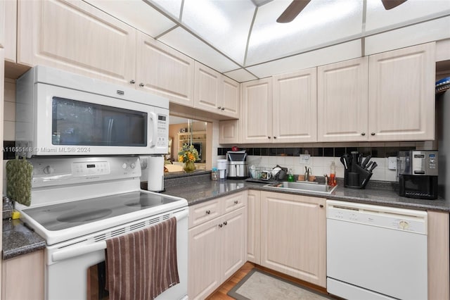 kitchen featuring white appliances, light hardwood / wood-style floors, tasteful backsplash, sink, and ceiling fan