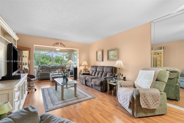 living room with a textured ceiling and light hardwood / wood-style floors