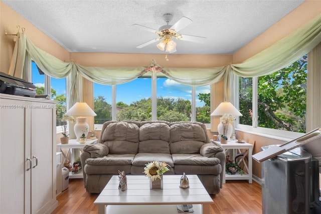 living room with a textured ceiling, a healthy amount of sunlight, ceiling fan, and hardwood / wood-style flooring