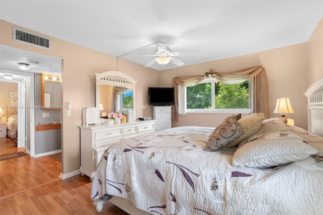 bedroom featuring a textured ceiling, ceiling fan, and light wood-type flooring