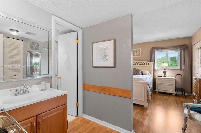 bathroom featuring hardwood / wood-style flooring, a textured ceiling, and vanity