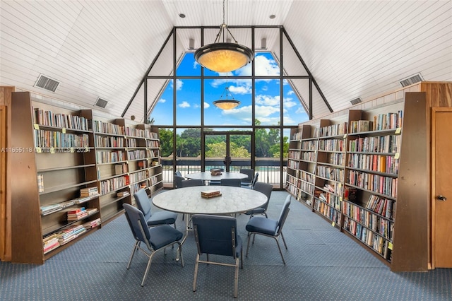 carpeted dining area featuring high vaulted ceiling