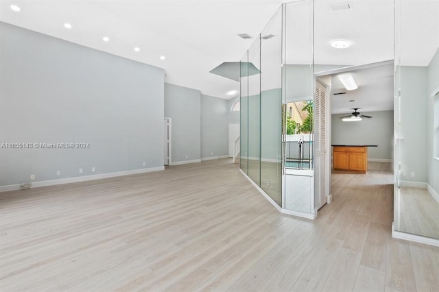 unfurnished room featuring ceiling fan, lofted ceiling, and light wood-type flooring