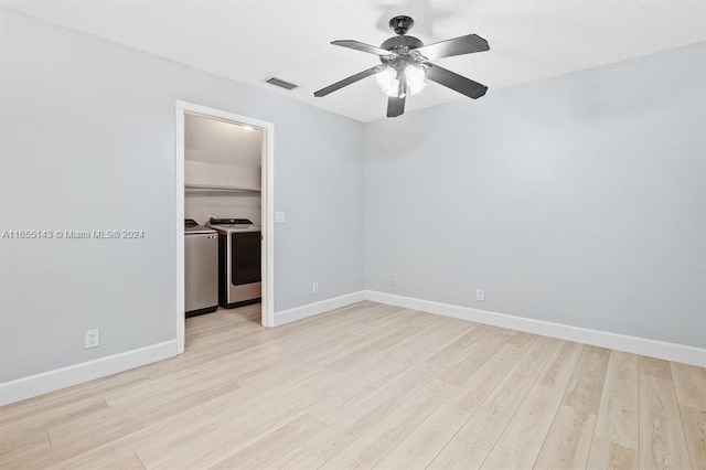 unfurnished room featuring independent washer and dryer, light wood-type flooring, and ceiling fan