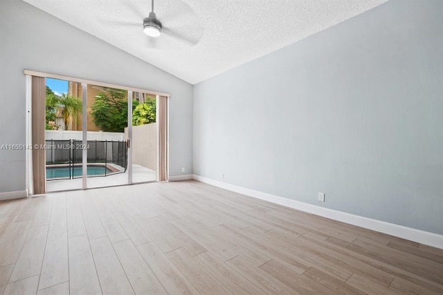 unfurnished room with ceiling fan, light wood-type flooring, a textured ceiling, and vaulted ceiling