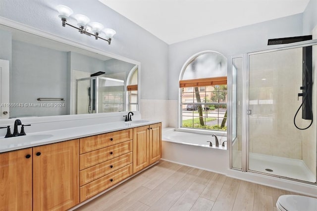 bathroom with hardwood / wood-style flooring, vanity, and separate shower and tub