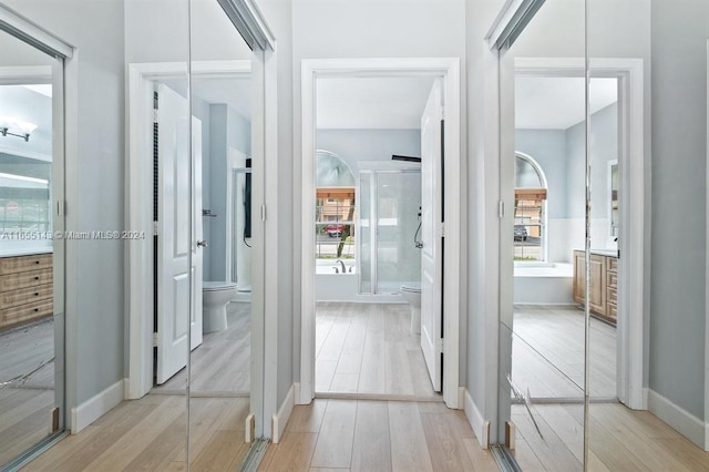 hallway with light hardwood / wood-style floors