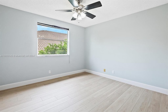 empty room with ceiling fan, a textured ceiling, and light wood-type flooring