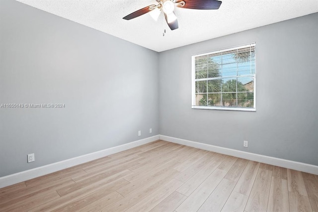 unfurnished room with ceiling fan, light wood-type flooring, and a textured ceiling