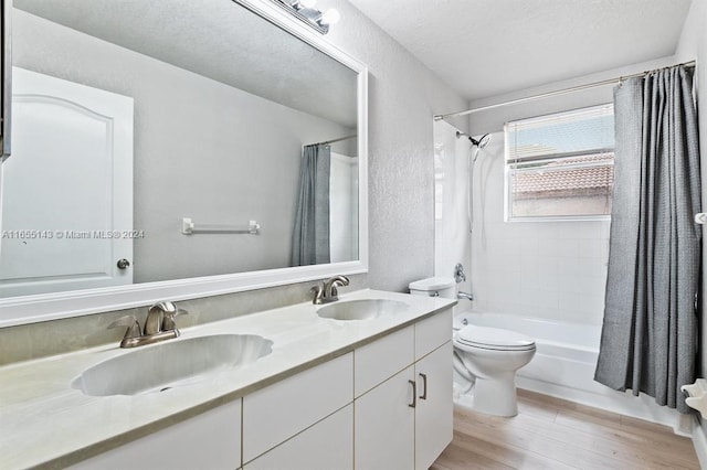 full bathroom with shower / bath combo, vanity, a textured ceiling, wood-type flooring, and toilet