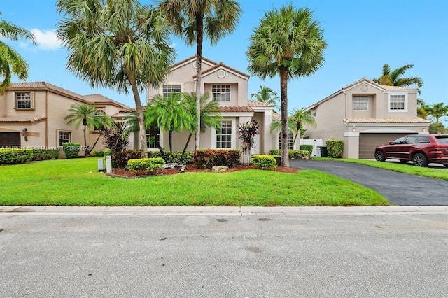 mediterranean / spanish-style house with a front yard and a garage