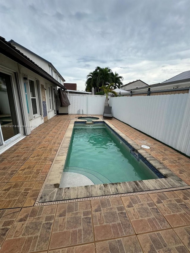 view of pool featuring a patio and an in ground hot tub