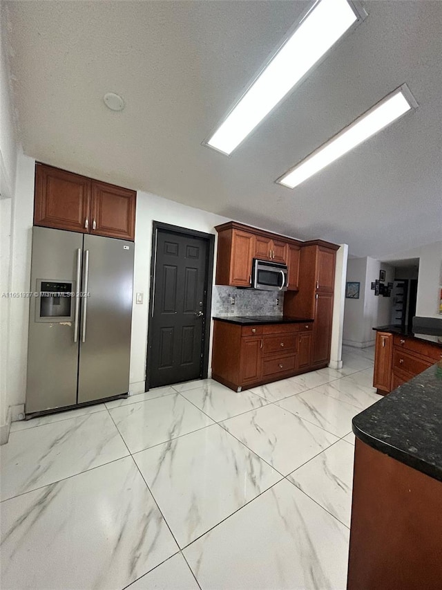 kitchen featuring backsplash, stainless steel appliances, and a textured ceiling