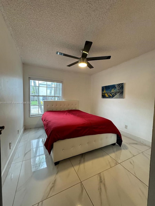 bedroom with a textured ceiling and ceiling fan