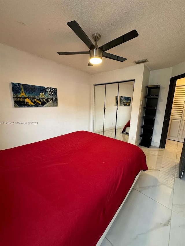 bedroom featuring a textured ceiling, a closet, and ceiling fan