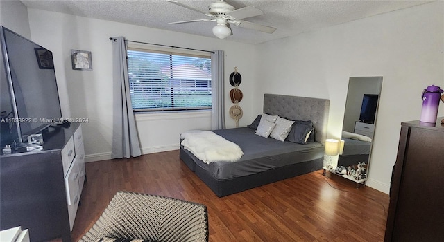 bedroom featuring dark hardwood / wood-style flooring, ceiling fan, and a textured ceiling