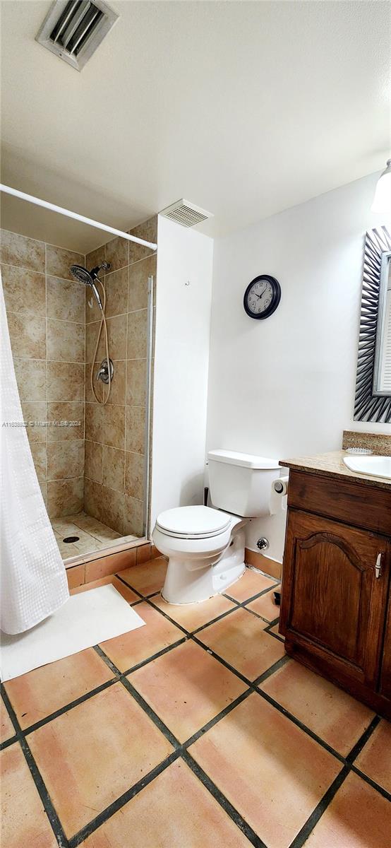 bathroom featuring vanity, toilet, a shower with shower curtain, and tile patterned floors