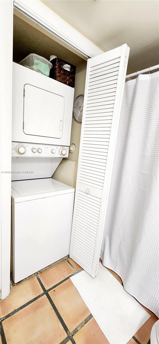 clothes washing area featuring stacked washer / drying machine