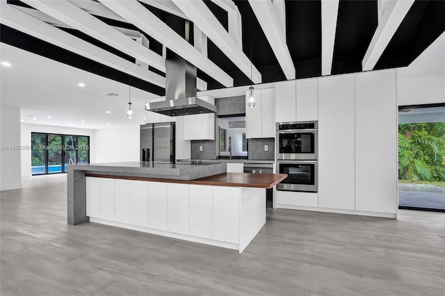 kitchen featuring pendant lighting, white cabinets, a center island, island exhaust hood, and stainless steel appliances