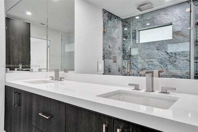 bathroom with a shower with shower door and vanity