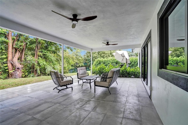 unfurnished sunroom with ceiling fan