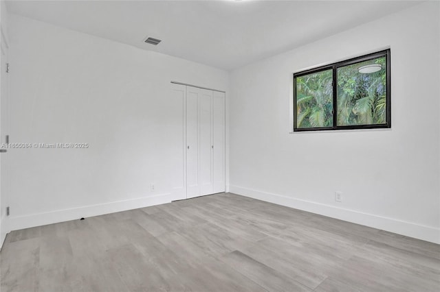 empty room with light hardwood / wood-style flooring