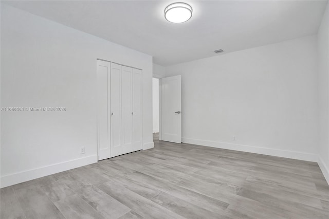 unfurnished bedroom featuring a closet and light hardwood / wood-style flooring