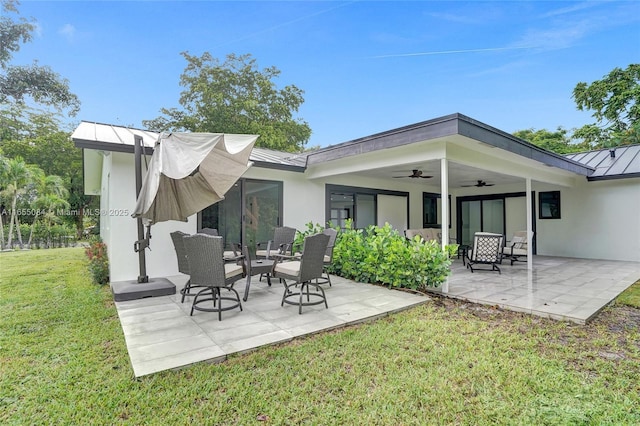 back of house with ceiling fan, a yard, and a patio